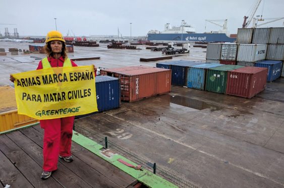 Activista protestando en el puerto de Bilbao con la pancarta 'Armas marca España para matar civiles'