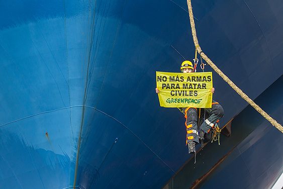 Activista despliega pancarta en uno de los barcos que lleva armas al conflicto