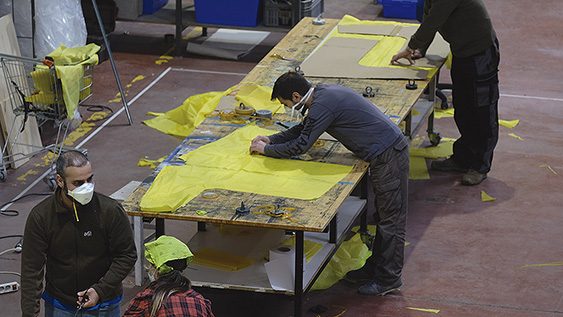 Voluntarios confeccionando batas para los trabajadores de centros de mayores a partir de pancartas de Greenpeace recicladas