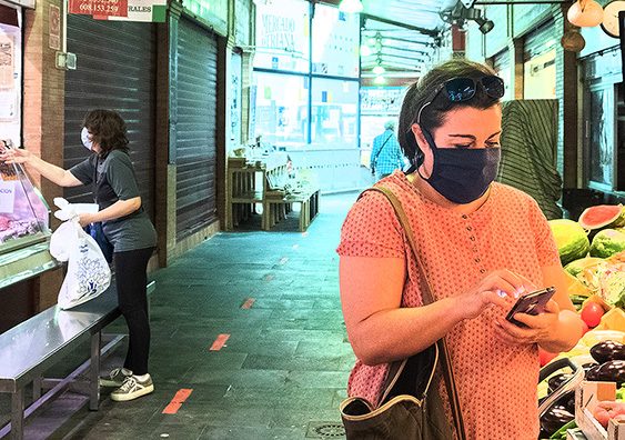 Mujeres comprando en el mercado con las mascarillas puestas