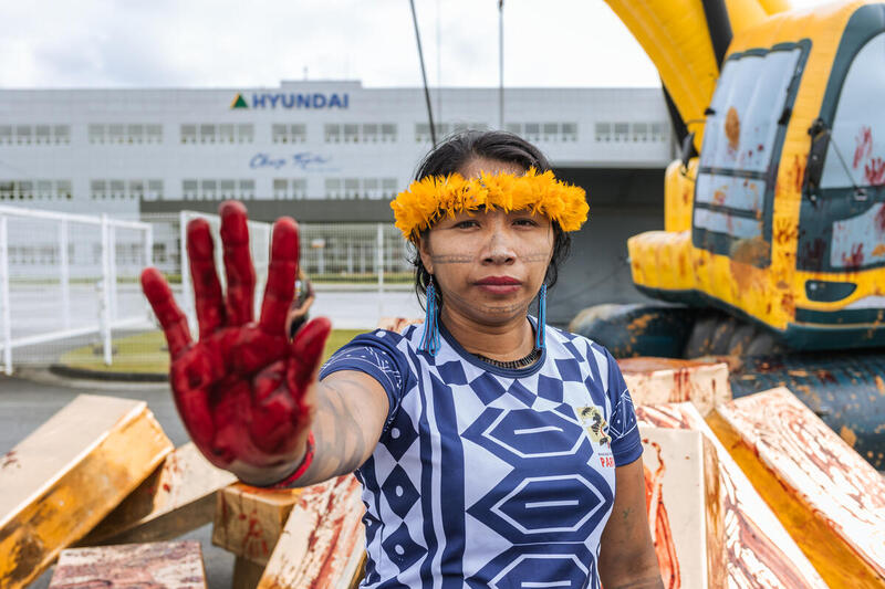 Activistas de Greenpeace Brasil y líderes indígenas celebran una acción pacífica levantando sus manos manchadas de rojo