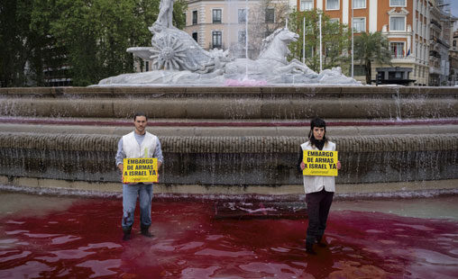 Activistas de Greenpeace tiñeron de color rojo sangre el agua de las tres fuentes que marcaron el recorrido de la manifestación estatal en favor del pueblo palestino en Madrid