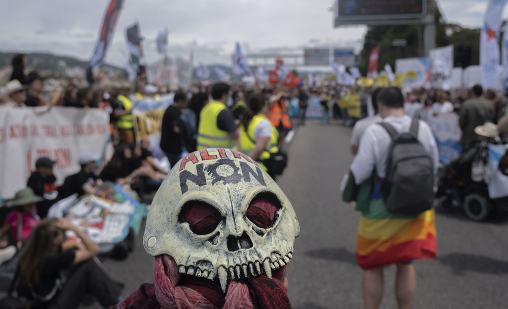 Momento de la manifestación en Ccontra de Altri en la que puede verse una cadavera con dientes en la que está escrito el lema ALTRI NON