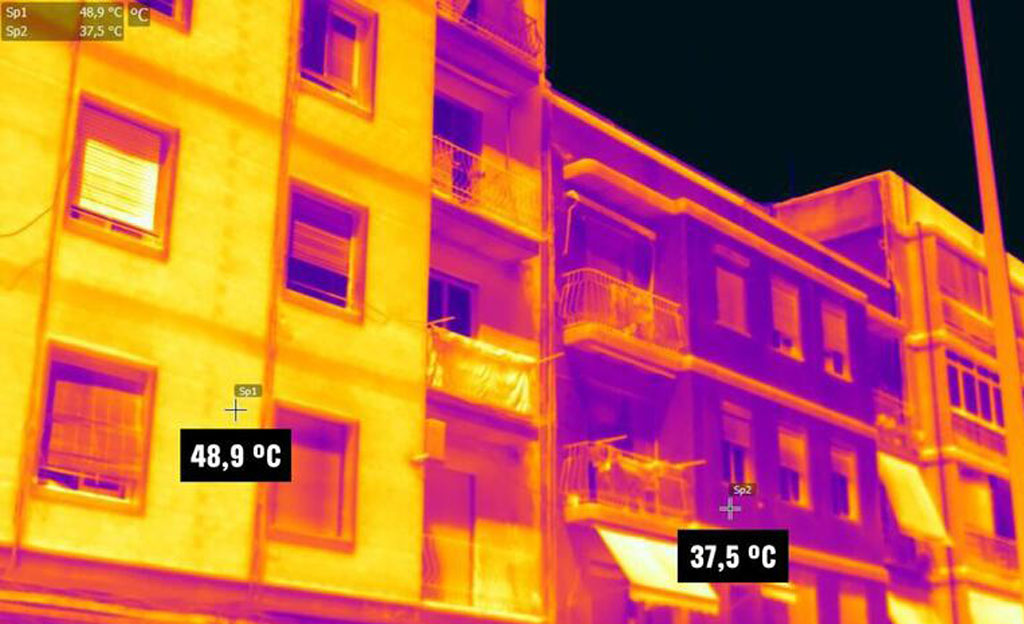 Imagen termográfica de una fachada en una ciudad española dónde se demuestra cómo el calor se cuela en las viviendas por ventanas, paredes y techos debido al mal aislamiento de los edificios.