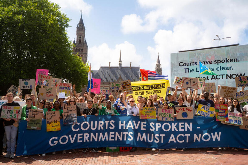 Líderes juveniles y comunidades de primera línea se manifiestan frente al Palacio de la Paz, sede de la Corte Internacional de Justicia tras la decisión de la CIJ que establece protecciones históricas que refuerzan las responsabilidades de los Estados en virtud del derecho internacional.