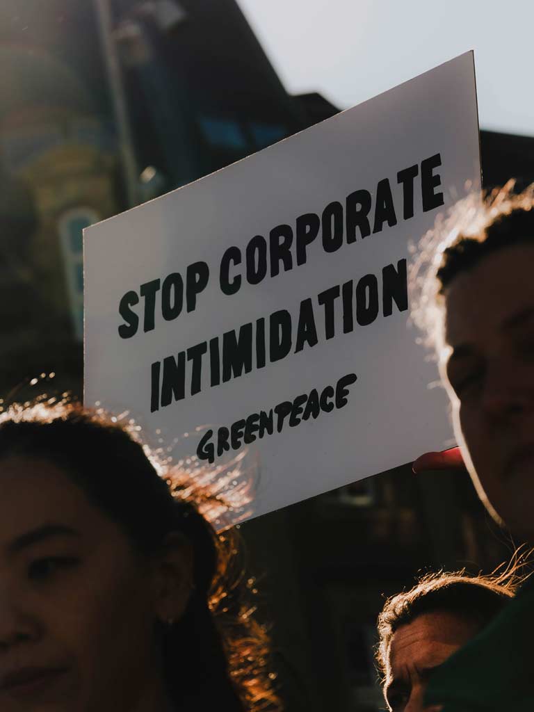 Acción solidaria de Greenpeace Países Bajos contra las demandas estratégicas contra la participación pública (SLAPP) en Ámsterdam, como parte de la red mundial, en respuesta a la sentencia del caso Energy Transfer contra entidades de Greenpeace.Se exhiben carteles con los lemas «Estoy con Greenpeace», «Es hora de resistir» y «No a la intimidación corporativa».