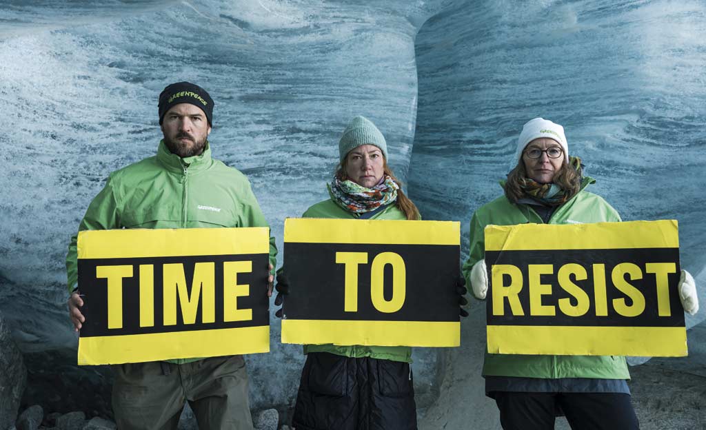 Activistas sujetan pancartas con el texto "TIME TO RESIST" en Suiza, en respuesta a la sentencia dictada en el caso de Energy Transfer contra las entidades de Greenpeace.